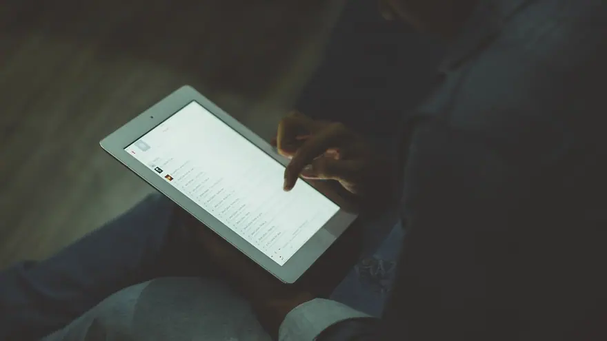 A person holding a tablet, scrolling through an app
